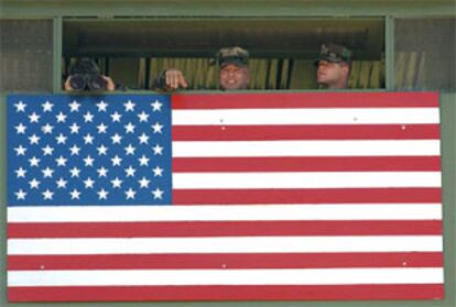 Tres <b></b><i>marines</i> vigilan la frontera entre Cuba y la base de Guantánamo desde un puesto de observación.