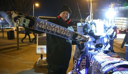 Un vendedor ambulante de Manchester muestra la bufanda del delantero español Álvaro Negredo
