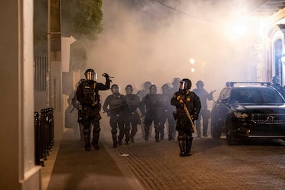 Policías antidisturbios patrullan por una calle de San Juan durante los enfrentamientos luego de una protesta para exigir la cancelación del contrato a Luma Energy.