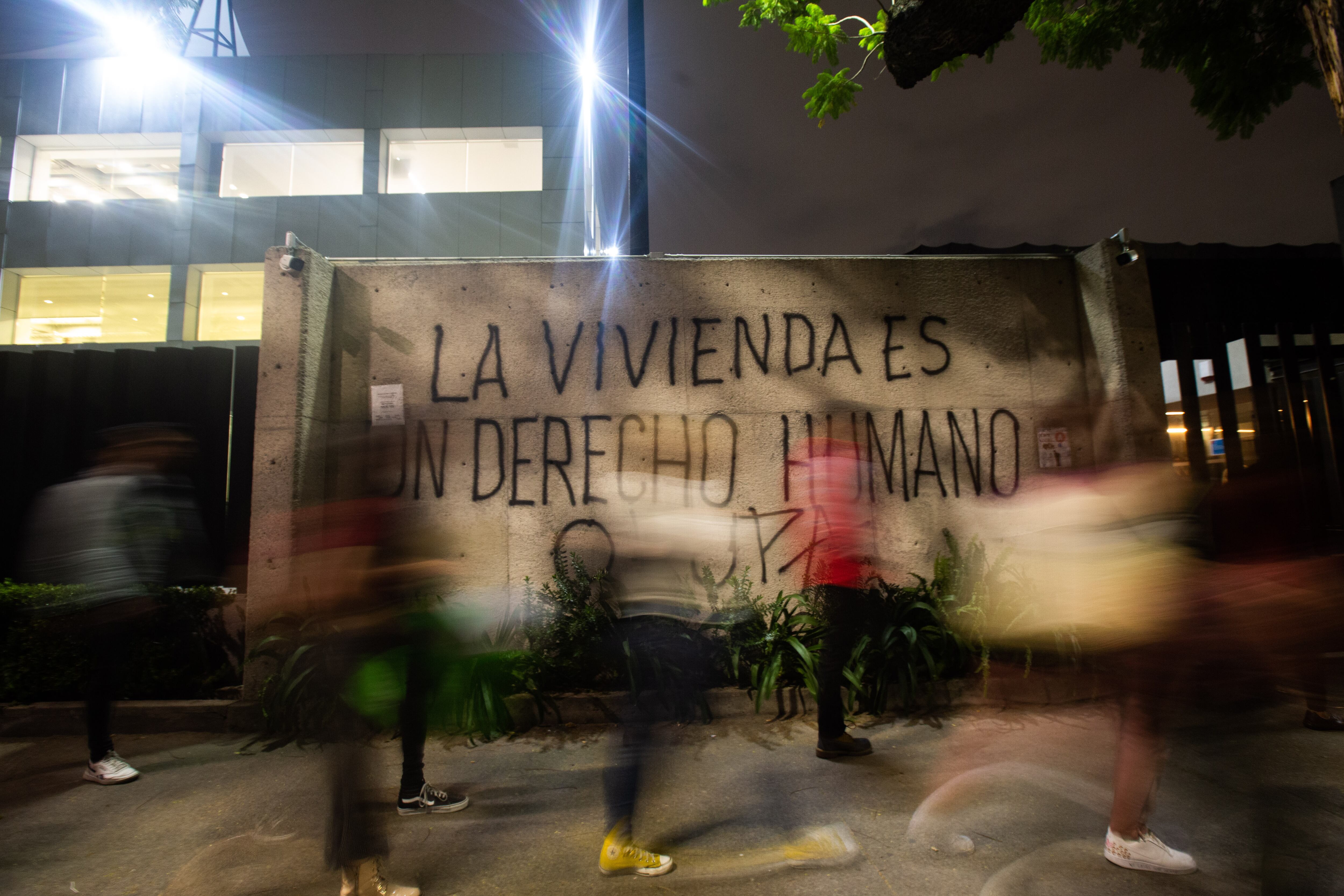 Ciudadanos caminan frente a una pancarta colocada frente a la Secretaría de Desarrollo Urbano y Vivienda, durante una protesta contra la gentrificación en noviembre de 2022.