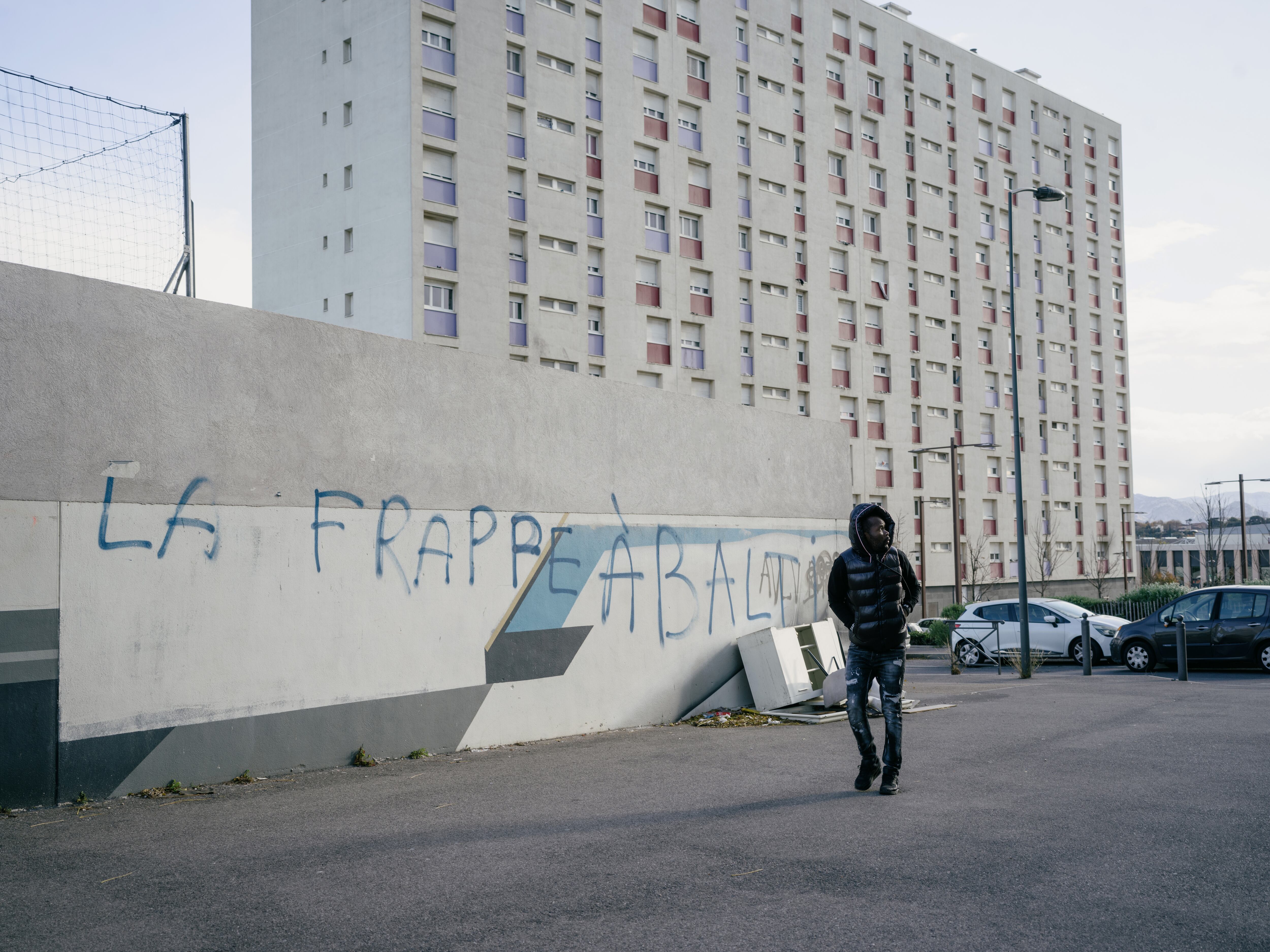 Un hombre pasa por delante de una pintada en el barrio de Malpassé, en el norte de Marsella. 