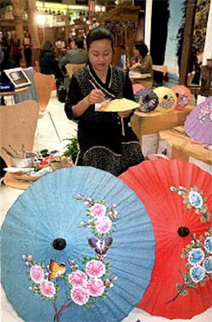 Artesana tailandesa pintando sombrillas de papel en la reciente Feria de Turismo (Fitur) celebrada en Madrid.