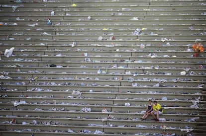 Unos turistas descansan en el sambódromo, lleno de basura, después del desfile anual de Carnaval en Río de Janeiro (Brasil).