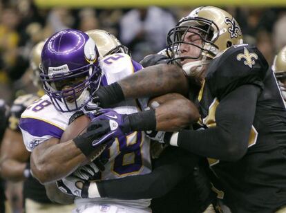 Un jugador de los Minnesota Vikings es frenado por Jonathan Vilma (der), de los New Orleans Saints, durante un partido de esta temporada.