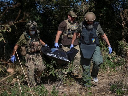 Militares ucranios trasladan el cadáver de un soldado ruso en una bolsa en la localidad de Blahodatne, en la región de Donetsk, ayer viernes.