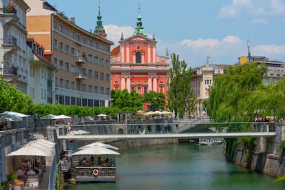 La iglesia de La Anunciación, de fachada rosada, vista desde el río Ljubljanica.