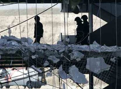 Bomberos y policías inspeccionan una de las plantas del aparcamiento de la T-4 destrozada por la explosión.