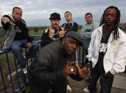 Figuras de los inicios y del momento actual del <i>rap</i> en Torrejón, con la base aérea al fondo. De izquierda a derecha, Randy, Cerroman 1/29, Blue Ice, Frank T, DJ Lara y Señor T Cee.