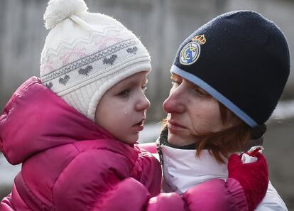 Un padre con su hija en la fila de inscripción de nuevos reclutas en el Ejército de Ucrania, en Kiev.