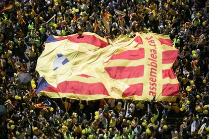 Una enorme bandera independentista es llevada por los manifestantes.