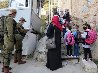 Profesoras y escolares palestinos, en un puesto de control israelí, en 2020 en Hebrón.