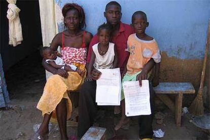 Gala Gay, a la puerta de su casa, con su esposa y sus hijos, muestra los documentos de expulsión.