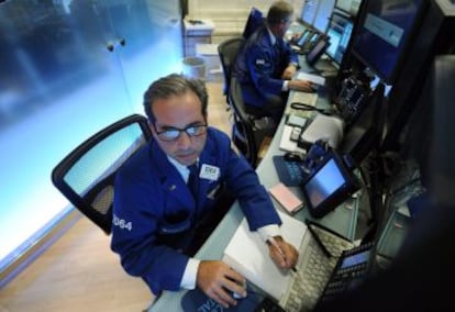 Un operador bur&aacute;til procesa &oacute;rdenes en el New York Stock Exchange