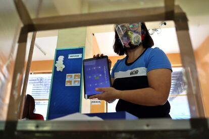 El reparto de tablets entre alumnos y ordenadores para los profesores ha sido una de las medidas más aplaudidas en el arranque del curso escolar, aunque solo ha llegado a algunos distritos de la capital, como Tondo, donde se ha prohibido hasta el uso del karaoke en horario diurno para facilitar la concentración. En la imagen, una maestra enseña a una madre el uso de este dispositivo en la escuela elemental Gregorio del Pilar, en el distrito de Tondo.