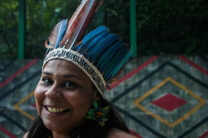 A indígena Carolina Potiguara com um cocar de penas vermelhas e azuis. “Nasci no Rio de Janeiro. Meus avós emigraram na década de setenta, fugindo da seca nordestina. Sou professora da Universidade Federal Fluminense e tenho muito orgulho de ser indígena, mesmo vivendo no espaço urbano”, diz.