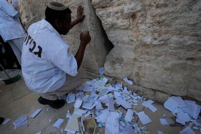 Un trabajador israelí retira los mensajes introducidos en las grietas Muro de las Lamentaciones.