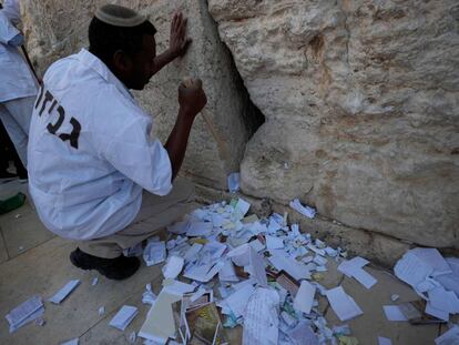 Un trabajador israelí retira los mensajes introducidos en las grietas Muro de las Lamentaciones.