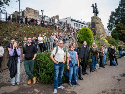 Un grupo de personas observa las salvas en honor a Isabel II, en los jardines de Princes Street, en Edimburgo, este viernes.