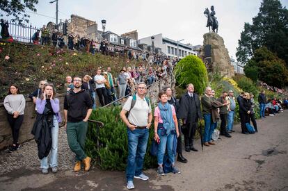 Un grupo de personas observa las salvas en honor a Isabel II, en los jardines de Princes Street, en Edimburgo, este viernes.