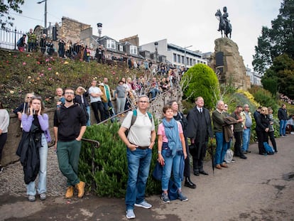 Un grupo de personas observa las salvas en honor a Isabel II, en los jardines de Princes Street, en Edimburgo, este viernes.