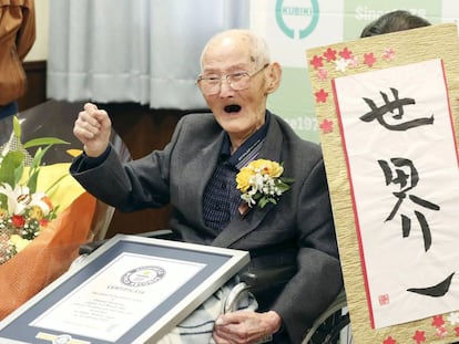 Watanabe junto a una caligrafía suya en japonés que reza
