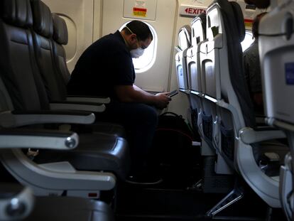 Un pasajero de un avión con mascarilla.