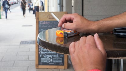 Una persona fuma en una terraza durante en Lugo.