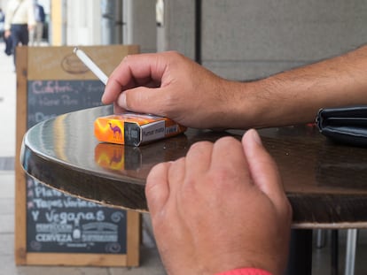 Una persona fuma en una terraza durante en Lugo.