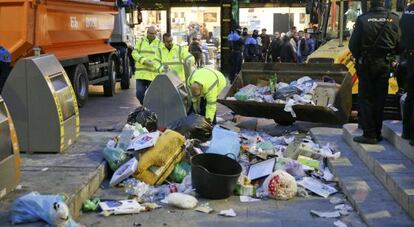 Operarios de una empresa privada realizan labores de limpieza en la calle Mayor