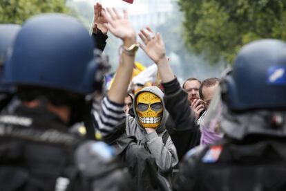 Jóvenes enmascarados se enfrentan a la policía durante una protesta en París.