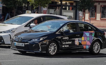 Un taxi junto a un VT de Cabify, en Sevilla.