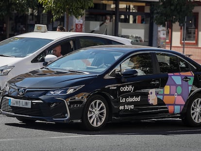 Un taxi junto a un VT de Cabify, en Sevilla.