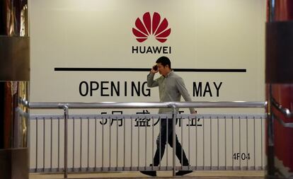 Un hombre camina frente a una tienda de Huawei que aun no ha sido inaugurada en Shanghi.