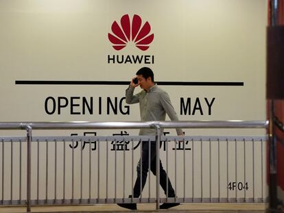 Un hombre camina frente a una tienda de Huawei que aun no ha sido inaugurada en Shanghái.