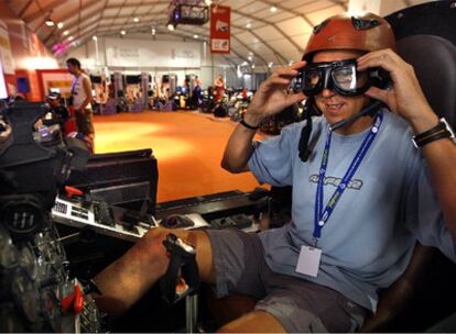 Un participante en la Campus Party prueba la cabina simulada de un avión de combate.