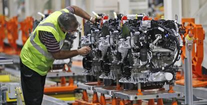 Un empleado de Ford trabaja con un motor di&eacute;sel en una planta de Londres.