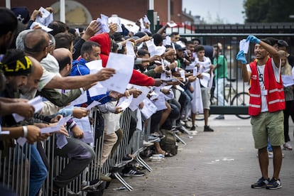 Solicitantes de asilo el pasado 17 de agosto mostrando sus documentos para obtener alojamiento en el centro de acogida de Ter Apel, en Groningen (Países Bajos).