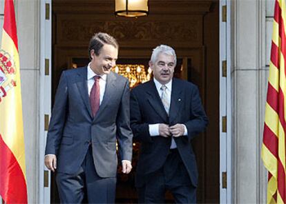 El presidente del Gobierno, José Luis Rodríguez Zapatero, y el de la Generalitat de Cataluña, Pasqual Maragall, flanqueados por las banderas española y catalana en la entrada del palacio de la Moncloa.