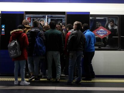 Decenas de viajeros tratan de entrar en un vagón del metro en la estación de Príncipe Pío.