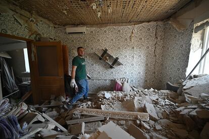 Yevhen, de 25 años, inspeccionaba este viernes la casa destruida de su madre tras el ataque ruso a las afueras de Kiev.  