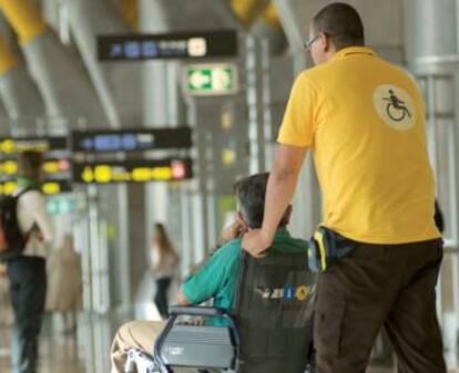 Un operario del servicio 'PMR' traslada a un viajero en Barajas.