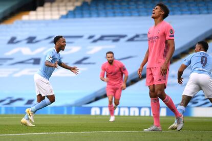 Sterling celebra el primer gol del City mientras Varane se lamenta.