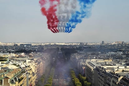 Los jets de la Patrouille de France colorean el cielo con la bandera nacional sobre los Campos Elíseos mientras los aficionados dan la bienvenida a los jugadores de la selección francesa de fútbol.