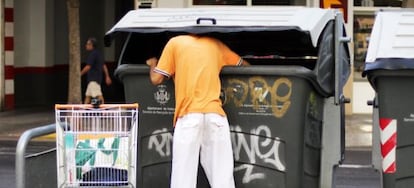 Un hombre rebusca en la basura, ayer, en las calles de Valencia.