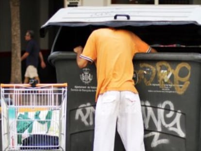 Un hombre rebusca en la basura, ayer, en las calles de Valencia.