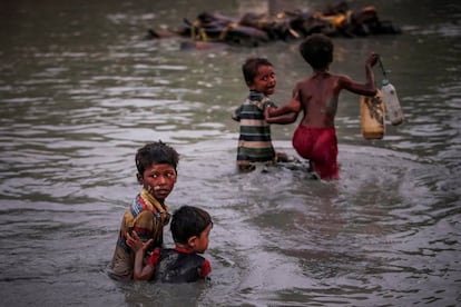 Os irmãos fogem da violência enquanto cruzam o rio Naf, ao longo da fronteira entre Bangladesh e Mianmar, em Palong Khali, perto do Cox's Bazar (Bangladesh), em 1º de novembro de 2017.