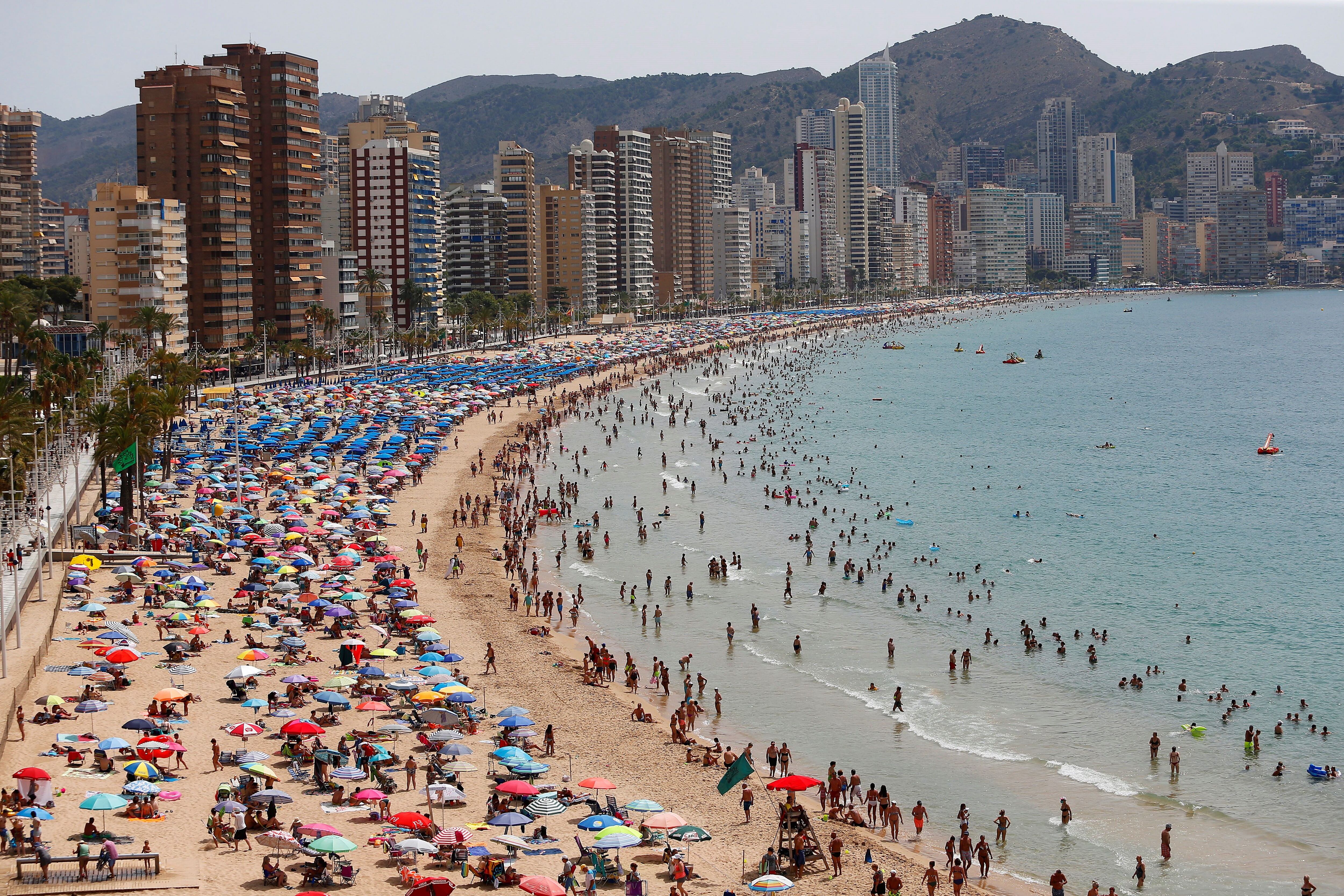 Cientos de turistas disfrutan de la playa de Levante de Benidorm (Alicante).