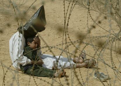 Una de las imágenes de los primeros días de la guerra es la de este padre junto a su hijo de cuatro años, detenidos pro el Ejército de EE UU cerca de Najaf, el 31 de marzo de 2003.