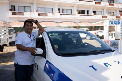 José Pérez (58 años) junto a su taxi, cuyo parabrisas se rompió durante el huracán.