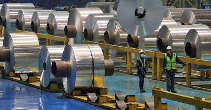 Dos trabajadores en una fábrica de aluminio.